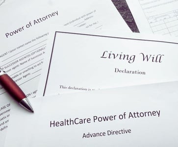 A splayed out stack of legal documents including Power of Attorney, Living Will, and HEalthCare Power of Attorney with Advance Directive.